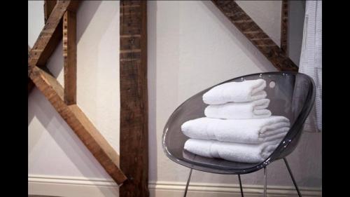 a stack of towels on a glass chair in a room at Beautiful City Centre Apartment Close to Minster in York