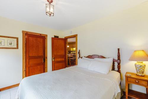 a bedroom with a white bed and a table with a lamp at Red Grill in Castleton
