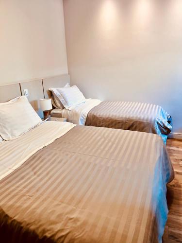 two beds in a hotel room with two beds at Hotel do Parque - Cunha in Cunha