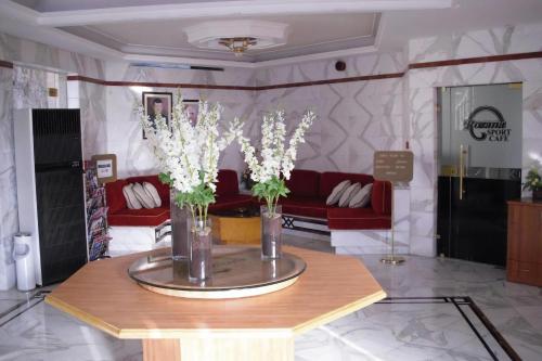 a lobby with a table with vases with flowers on it at Rozana Hotel in Amman