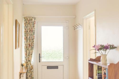 a white door with a window in a room at Meadow Lea in Leominster