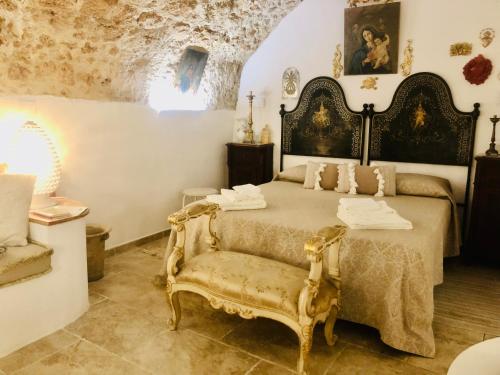 um quarto com uma cama e uma cadeira em Dimora Umberto - Dammuso Suite em Noto