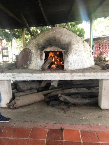 a stone oven with a fire inside of it at Hacienda Villa Liria in Hobo