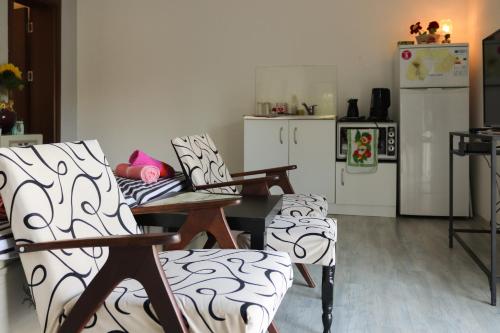 La cuisine est équipée d'une table, de chaises et d'un réfrigérateur. dans l'établissement Magnolia Apartments, à Gevgelija