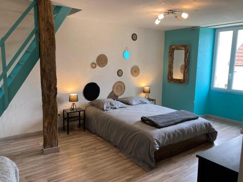 - une chambre avec un grand lit et des murs bleus dans l'établissement Gîtes du Noyer, à Praslay