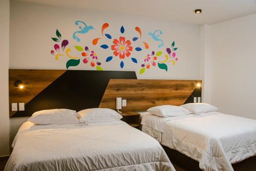 Platero Hotel في اياكوتشو: غرفة نوم بسريرين ولوحة على الحائط