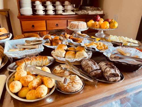 a buffet filled with different types of bread and pastries at Hotel do Parque - Cunha in Cunha