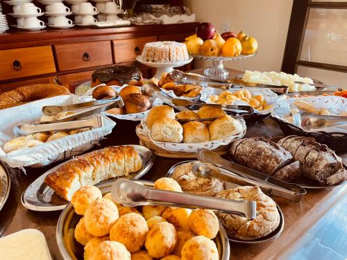 a table with many different types of bread and pastries at Hotel do Parque - Cunha in Cunha