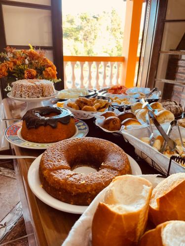 a table topped with lots of different types of pastries at Hotel do Parque - Cunha in Cunha