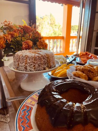 a table topped with a chocolate cake and plates of food at Hotel do Parque - Cunha in Cunha