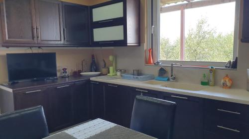 una cucina con armadi neri, lavandino e finestra di Wonderful Spot to Recharge a Kalamáta