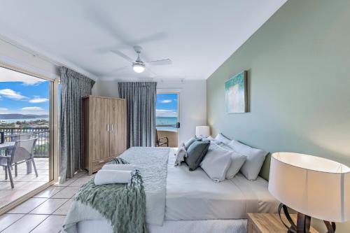 a bedroom with a large bed and a balcony at Casa Oceana - Airlie Beach in Airlie Beach