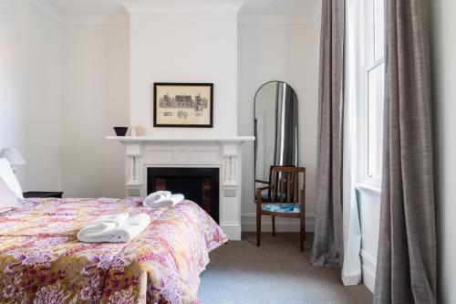 Schlafzimmer mit einem Bett, einem Kamin und einem Spiegel in der Unterkunft Luxury Apartment on Stuart in Dunedin