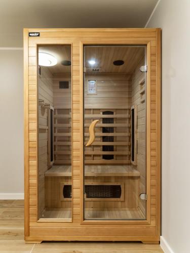 a large wooden closet with a glass door at Vincent Apartamenty Darłówek in Darłowo