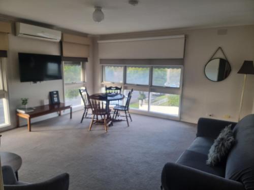een woonkamer met een bank en een tafel en stoelen bij Hacienda Motel Geelong in Geelong