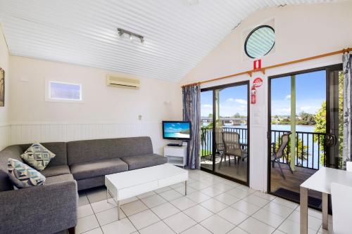 a living room with a couch and a tv at Moruya Holiday Park in Moruya