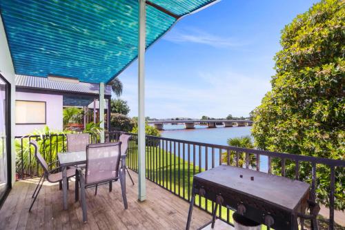 a patio with a table and chairs on a balcony at Moruya Holiday Park in Moruya