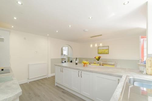 a white kitchen with a sink and a counter at Roseberry House in Guisborough