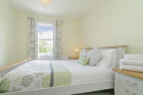a white bedroom with a bed and a window at Roseberry House in Guisborough