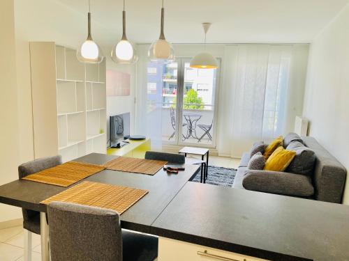 a kitchen and living room with a table and a couch at Limpertsberg cosy 1 bedroom. Terrace and Parking in Luxembourg