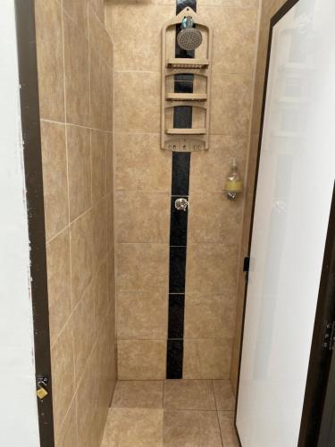 La salle de bains est pourvue d'une douche et d'une étagère. dans l'établissement Habitación independiente Baño exterior, à Armenia