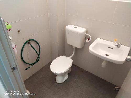 een badkamer met een toilet en een wastafel bij Ainur Homestay in Melaka