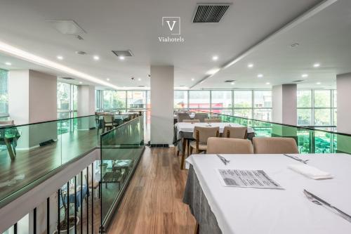 a dining room with tables and chairs and windows at VH Eurostar Tirana Hotel Congress & Tirana Spa in Tirana