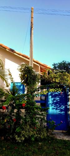 a house with a blue door with plants on it at Casinha do Bem-Viver na Vila de Itaúnas in Itaúnas