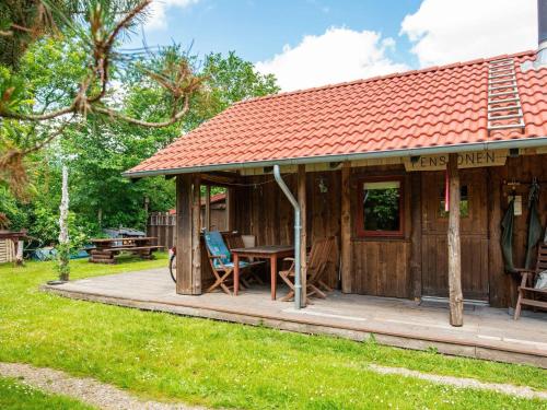 a wooden cabin with a table and chairs on a deck at 6 person holiday home in Hovborg-By Traum in Hovborg