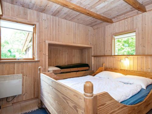 a bedroom with a large bed in a wooden cabin at 6 person holiday home in Hovborg-By Traum in Hovborg
