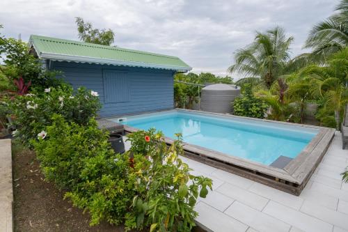 a swimming pool in front of a house at Le Domharry in Anse-Bertrand