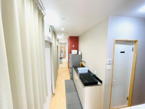 a kitchen with a stove and a refrigerator at Mcity in Wakasa in Naha