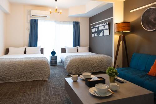 una habitación de hotel con dos camas y un sofá en 谷町君･星Hotel･恵美須西, en Osaka