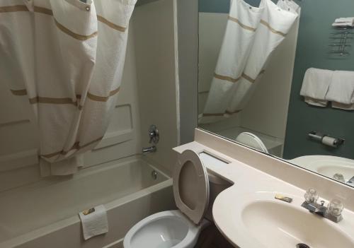 a bathroom with a sink and a toilet and a mirror at America's Inn - Birmingham in Birmingham