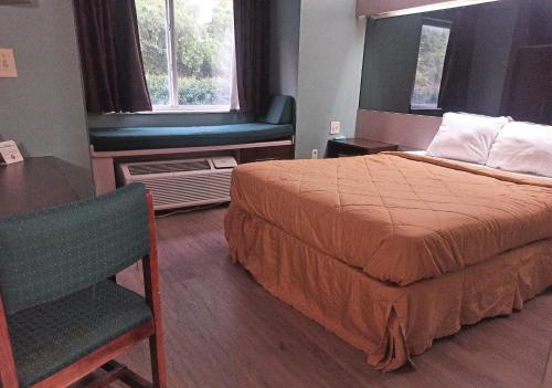 une chambre d'hôtel avec un lit et une chaise dans l'établissement America's Inn - Birmingham, à Birmingham