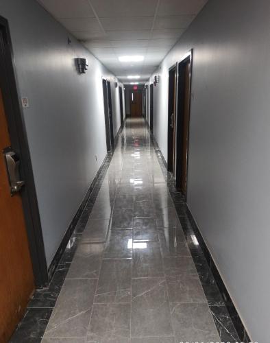 un long couloir avec du carrelage dans un bâtiment dans l'établissement America's Inn - Birmingham, à Birmingham