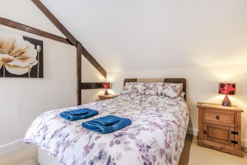 a bedroom with a bed with two blue towels on it at The Yoke in Tedburn Saint Mary