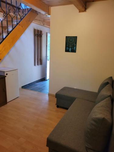 a living room with a couch and a staircase at Mohás Vendégház Kőszeg Mohás út 107 in Kőszeg