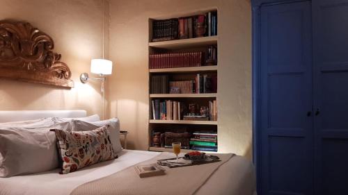 a bedroom with a bed, bookshelf and a lamp at Candelaria House Boutique in Bogotá