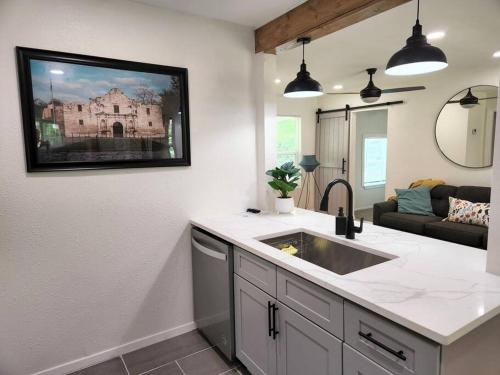 uma cozinha com um lavatório e uma sala de estar em Modern Home in Central San Antonio! em San Antonio