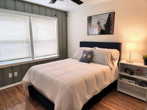 a bedroom with a large bed and two windows at Modern Home in Central San Antonio! in San Antonio