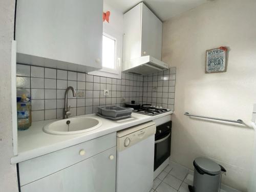 eine kleine Küche mit einer Spüle und einem Herd in der Unterkunft Maison Sarzeau, 3 pièces, 4 personnes - FR-1-639-19 in Sarzeau
