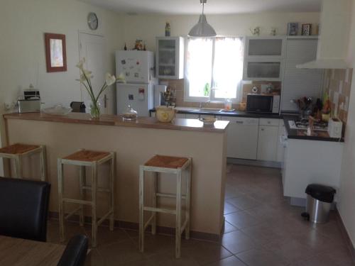 - une cuisine avec un comptoir et des tabourets dans l'établissement Maison de charme avec terrasse, jardin et équipements complets, à 2 km de Neuvic - FR-1-616-110, à Neuvic