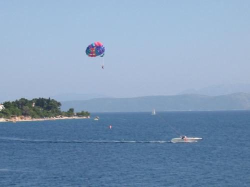 a person on a boat in the water with a kite at Apartments Waterfront Ivan in Podgora