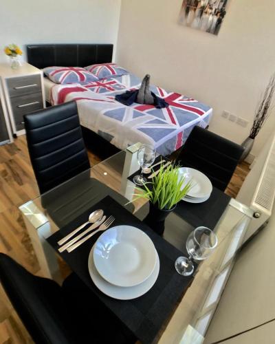 a dining table with two white plates on top of it at City Sparrow Nest - 7W in London