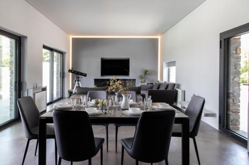 a dining room with a table and chairs at Villa drys II in Elliniká