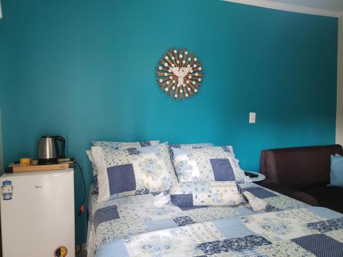Dormitorio azul con cama y pared azul en Suítes Ambiente Familiar -Prox do Thermas en Águas de São Pedro