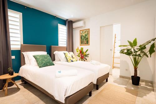 מיטה או מיטות בחדר ב-Villa Cocotier à 50 mètres de la plage