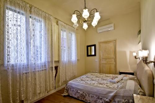 1 dormitorio con cama, ventana y lámpara de araña en San Marco Apartment en Florence