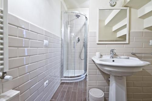 a white bathroom with a sink and a shower at San Marco Apartment in Florence